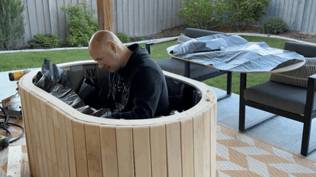 Wooden cold plunge barrel in a backyard, used for cold water immersion to support recovery, wellness, and morning routines.