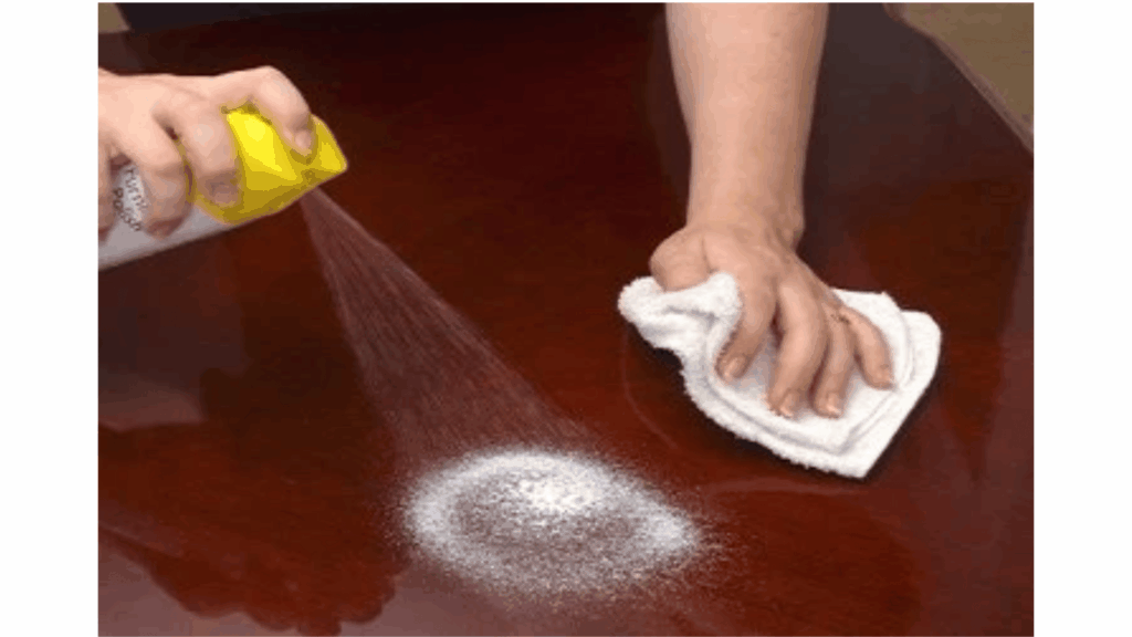 Wood furniture being carefully cleaned and maintained with a soft cloth and suitable wood-safe cleaning products.