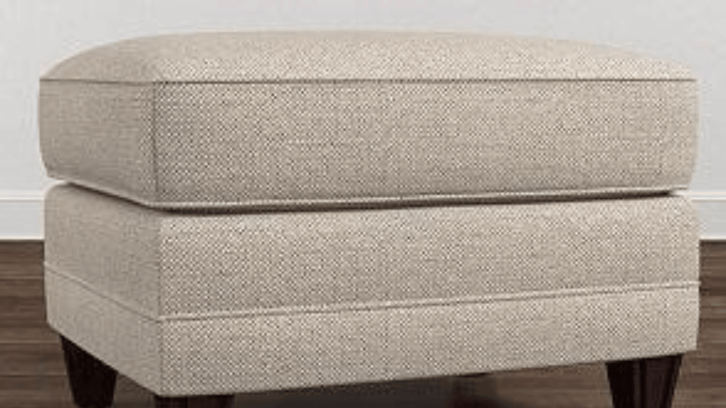 Stylish upholstered ottoman used as a versatile seating and décor piece in a living room